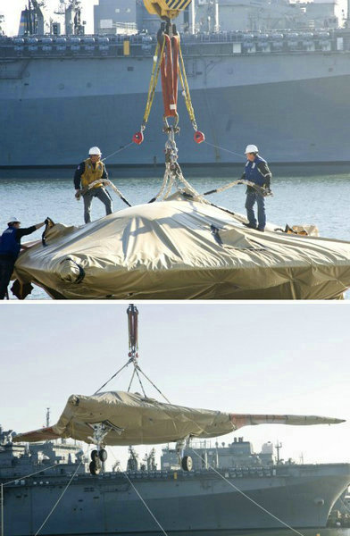 資料圖：美國(guó)海軍人員將一架X-47B無(wú)人空戰(zhàn)系統(tǒng)驗(yàn)證機(jī)運(yùn)送到杜魯門(mén)號(hào)航母上。