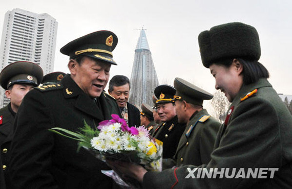 11月22日，中國國務(wù)委員兼國防部長梁光烈（左）在平壤祖國解放戰(zhàn)爭勝利紀(jì)念塔廣場接受獻(xiàn)花。新華社記者姚西蒙攝