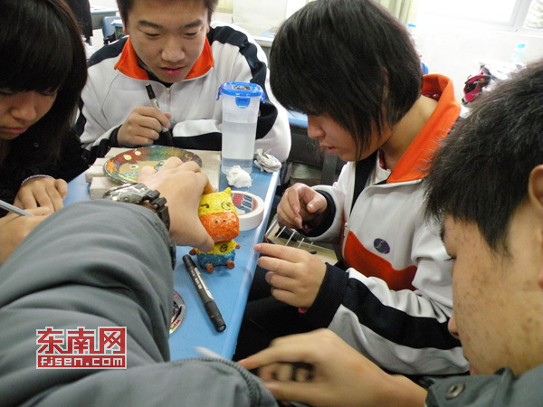 同學(xué)們?cè)诶蠋煹闹笇?dǎo)下制作心愿卡作品。