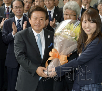 12月18日，高票當(dāng)選東京都新知事的豬瀨直樹正式到任。圖為豬瀨從政府職員手中接過花束。(共同社)