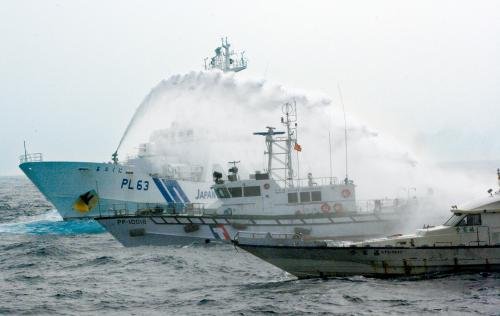 臺灣“海巡署”的巡邏船（中）在掩護(hù)保釣船“全家?！碧枺ㄓ遥┒惚苋毡竞Ｉ媳０矎d巡視船的水炮攻擊。