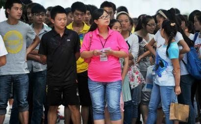 6月7日，雅安天全中學的呂莎莎老師(中)在考場外等待自己的學生出來。