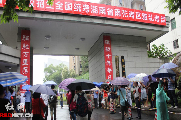 高考學(xué)子冒雨進入考場。
