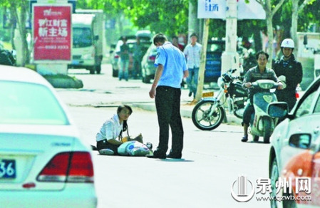 女孩從摩的上摔下，跌坐路中央，恰遇社區(qū)聯(lián)防巡邏人員扶起。