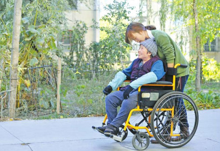 10月11日，張學(xué)琴用輪椅推著母親在校園里散步。
