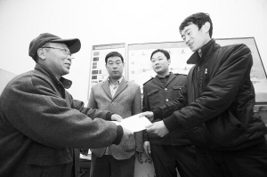 劉大爺莊重地將感謝信交到車隊(duì)隊(duì)長(zhǎng)的手中。本報(bào)記者 李志華 攝