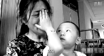 視頻中“小中寶”看到奶奶為他掉眼淚，就伸手為奶奶抹去眼淚。視頻截圖 