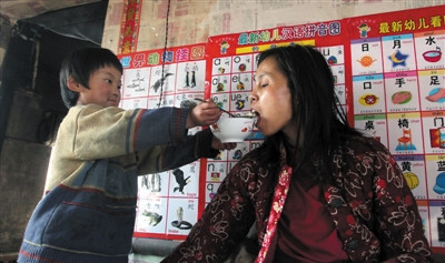 小孫悅為臥床的母親喂飯。