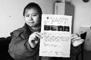 女孩眼含淚水向記者出示自己母親的診斷報(bào)告，希望好心人可以幫幫她的母親?！　z影 李自強(qiáng)