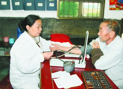 曾玉萍(左)在為患者看病。 喻無瑕 攝