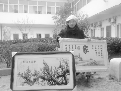 胡海珠和她繪制的“十字繡”。馮勁松 攝