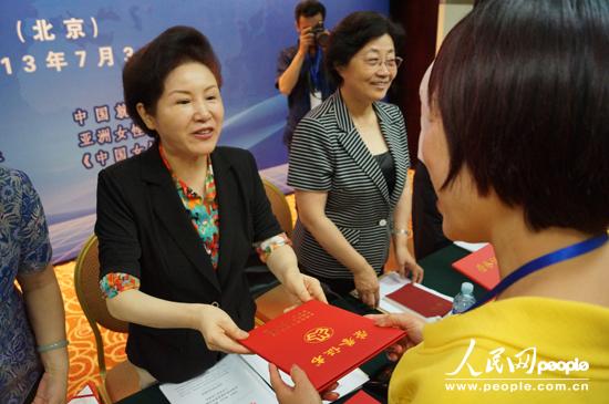 全國(guó)婦聯(lián)黨組副書記、副主席、書記處書記孟曉駟為獲獎(jiǎng)?wù)哳C發(fā)榮譽(yù)證書