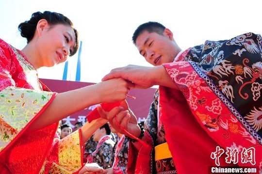 9月1日，一場(chǎng)別開生面的“重溫漢唐風(fēng)”漢式集體婚禮在泉城濟(jì)南舉行，72名新人身著傳統(tǒng)漢服喜結(jié)良緣，并在許愿墻上許下“千年共枕眠，一世永相愛”心愿。圖為新人解纓結(jié)發(fā)。中新社發(fā) 張勇 攝