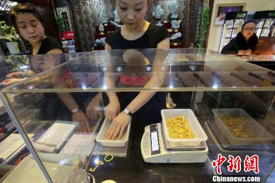 金店工作人員正在稱重?！堅啤z