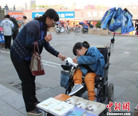 洛洛正在給買書的顧客簽名。 馮曉林 攝