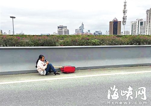 女子被拽下后，坐在三環(huán)路應(yīng)急車道上喝水