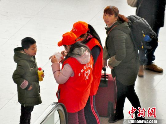 鐵路青年志愿者為攜帶兒童出行的旅客提供咨詢解答?！钦鳌z