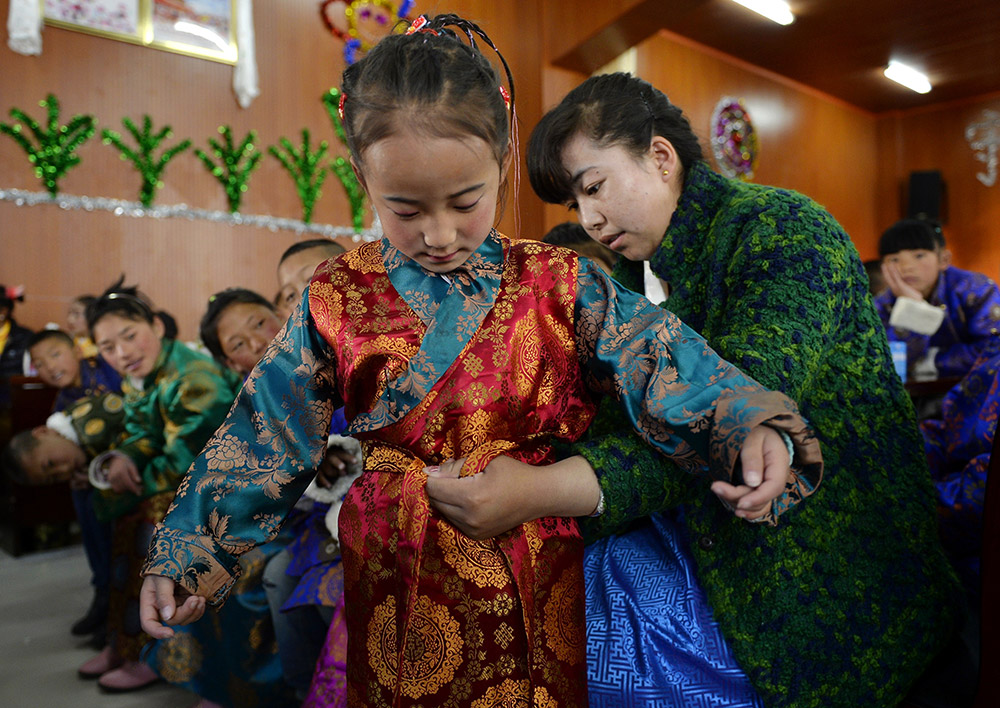 2月27日，在西藏自治區(qū)兒童福利院，來自拉薩市尼木縣的“愛心媽媽”德慶旺姆（右）在為來自那曲地區(qū)的嘎瑪曲宗換上節(jié)日盛裝。